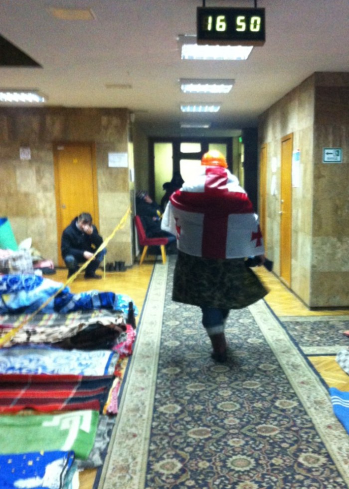 A protester wraps himself in a Georgian flag in the Trade Union offices in Independence Square