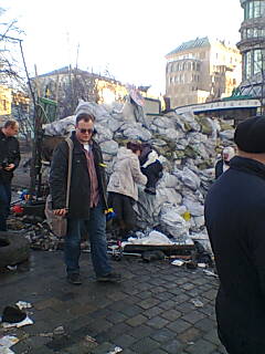 In the middle, a dead woman is lying on the barricade.  Another woman checks for life.